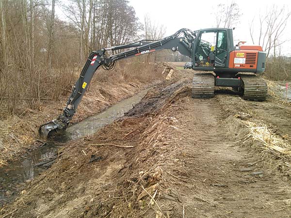 Moor-Kettenbagger an Gräben in Wald und Flur Moor-Kettenbagger an Gräben in Wald und Flur